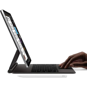 A Space Gray iPad Pro 2nd gen 11-inch placed on a table with a keyboard and Apple Pencil beside it. A man's hand is interacting with the iPad screen, creating a professional and modern workspace setup